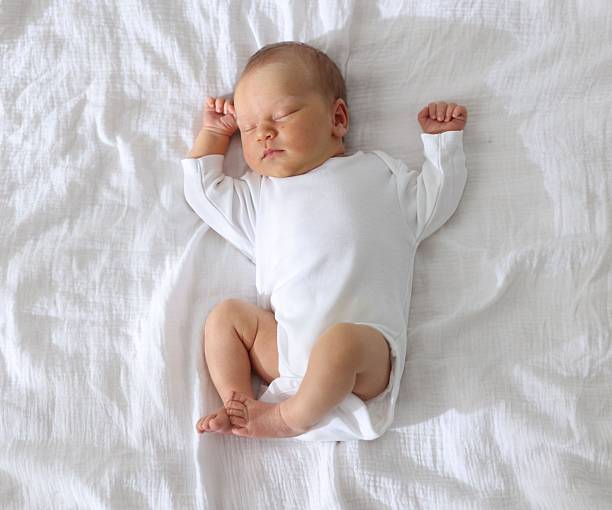 istock Cute newborn baby sleeping on bed, top view 2242421977