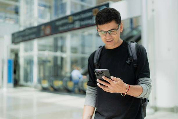 istock Man traveling in airport using mobile phone 2242425610