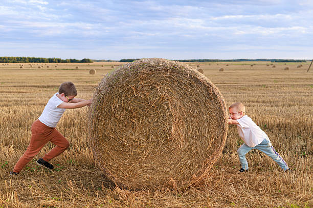 Smiling Male Child Playing In Haystack
