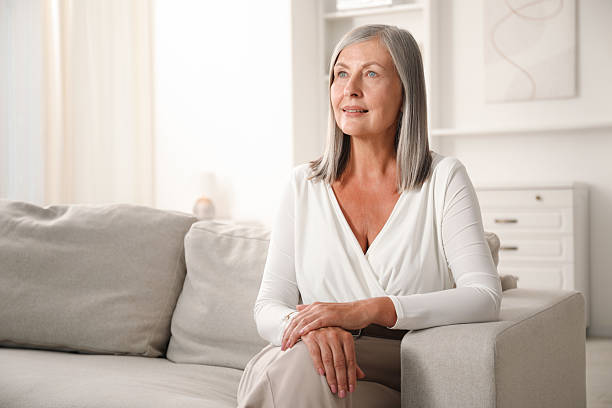 istock Elegant senior woman on sofa at home. Space for text 2242426564