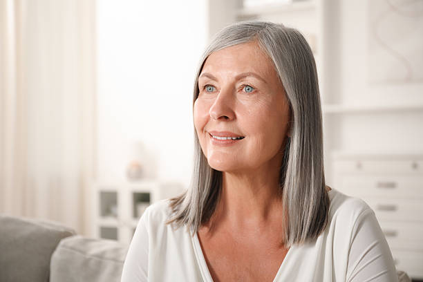 istock Elegant senior woman on sofa at home 2242426590