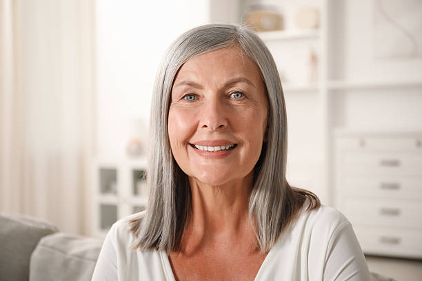 istock Elegant senior woman on sofa at home 2242426968
