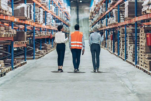 istock Back view of business people walking side by side in warehouse 2242427058