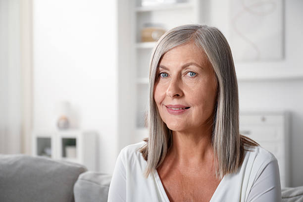 istock Elegant senior woman on sofa at home. Space for text 2242427133