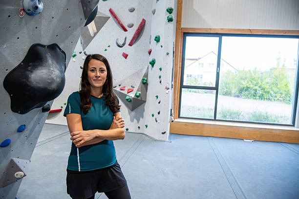 istock Climber Woman Smiling Inside Indoor Rock Gym 2242427449