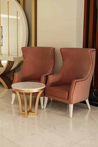 istock Two elegant pink chairs flank a round white table, creating a welcoming seating area. The modern decor features smooth lines and a bright atmosphere 2242428079