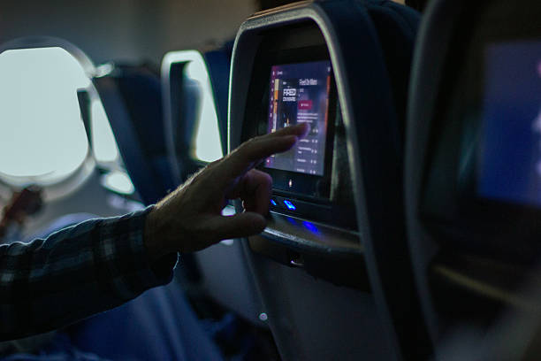 istock Passenger selecting a movie on touchscreen during airplane flight 2242429192