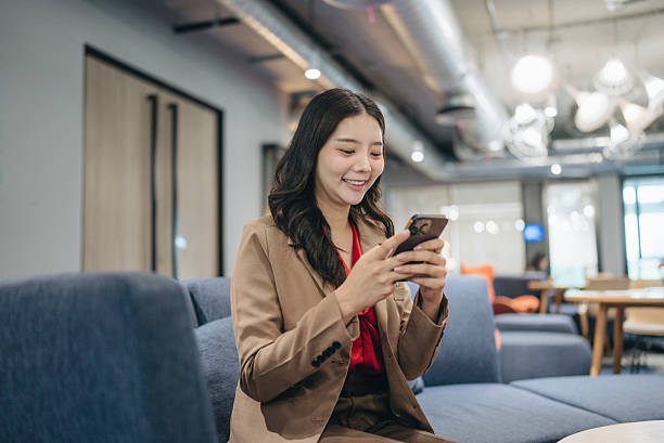 istock attractive young business person sending a text while walking through her office building 2242429302
