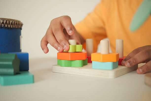 istock Child playing with colorful wooden shape sorting toys 2242429391