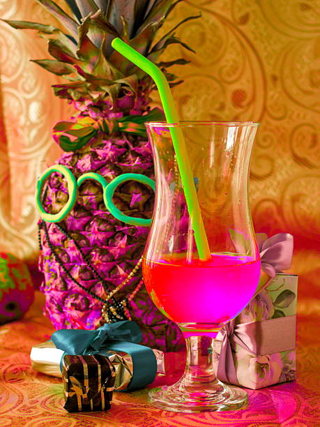 A tropical psychedelic crazy celebration concept featuring a funny pineapple with sunglasses and a colorful drink.