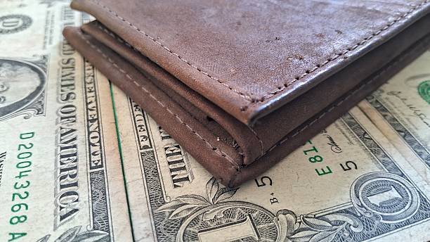 istock Brown Leather Wallet and US Dollar Bills on Green Surface 2242431722