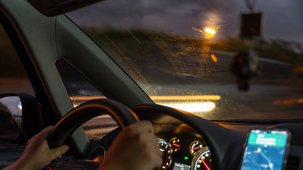istock Driving car on wet road at night with navigation app 2242435187
