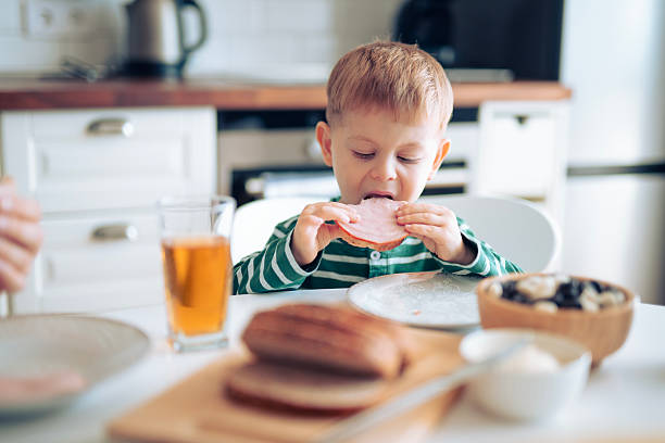 istock Cute little boy having his breakfast in the morning. 2242437703