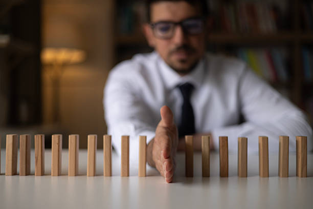 Businessman Stop Domino Effect. Risk Management and Insurance Concept
