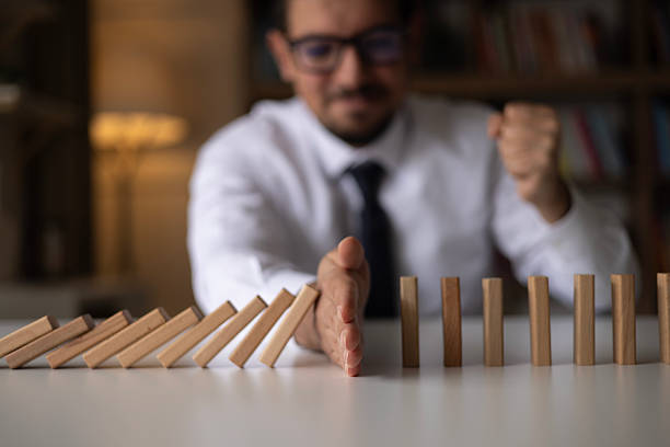 istock Businessman Stop Domino Effect. Risk Management and Insurance Concept 2242438393