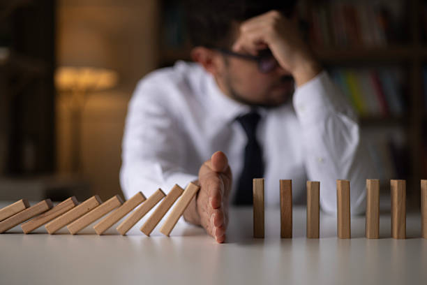 istock Businessman Stop Domino Effect. Risk Management and Insurance Concept 2242439413