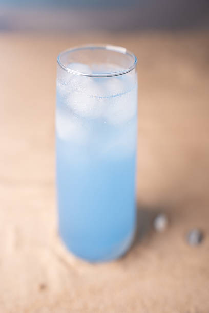 istock chilled blue beverage in tall glass on sandy beach surface with soft focus background evokes refreshing summer vibes and cool relaxation in tropical setting, light, marine, simplicity, idyllic 2242439454