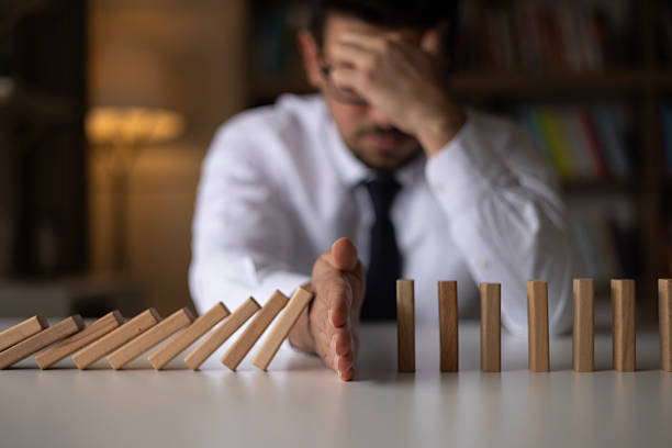 istock Businessman Stop Domino Effect. Risk Management and Insurance Concept 2242439497