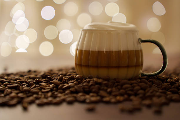 istock cozy coffee blend captured amidst rich brown beans and soft golden bokeh, featuring a delicate foam-topped beverage in a ceramic mug, epitomizing warmth and comfort, subtle, mellow, elegant 2242439526