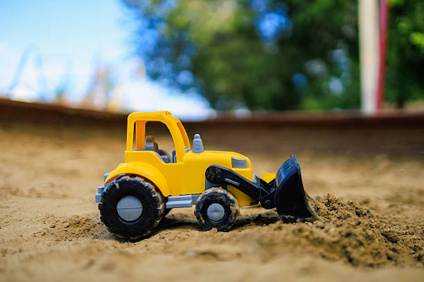 istock Toy excavator in the children's sandbox. Background with selective focus 2242442503