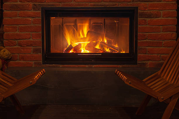 istock Real home fireplace with burning wood behind glass. Background with selective focus 2242442646