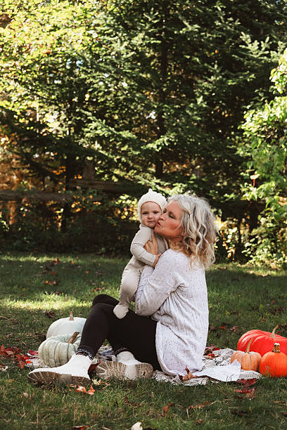 Baby Girl and Grandmother Sitting with Pumpkins