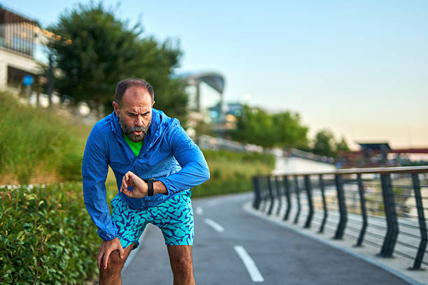 istock Man checking smartwatch during intense outdoor training session 2242446725