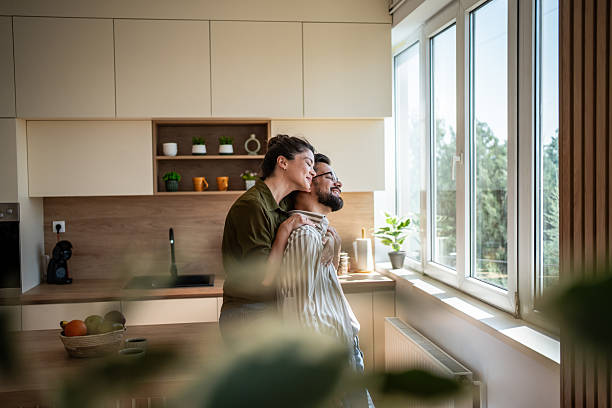istock Couple embracing in kitchen enjoying morning sunlight 2242447677