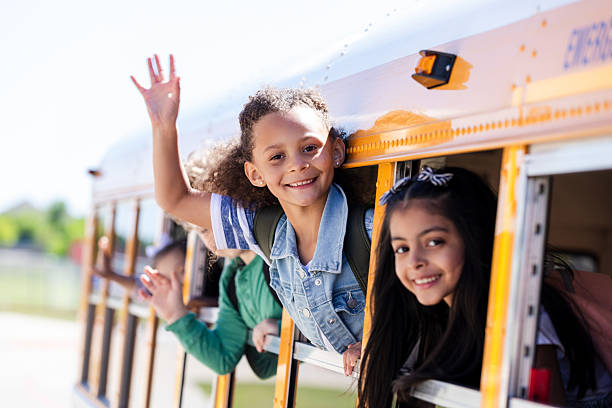 istock Joyful children wave goodbye from a school bus, anticipating a new day. 2242449624