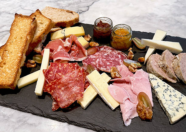 istock Gourmet charcuterie board with assorted cured meats, cheeses, toasted bread, nuts, grapes, and fruit jams. 2242450977