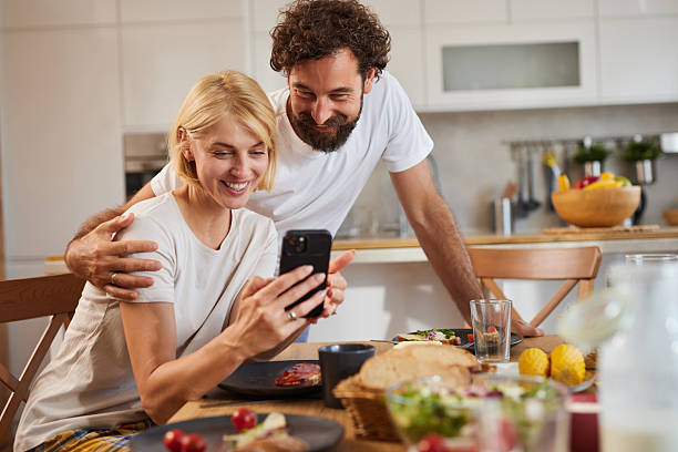 istock Couple enjoying a joyful moment while looking at a smartphone during a cozy 2242458251