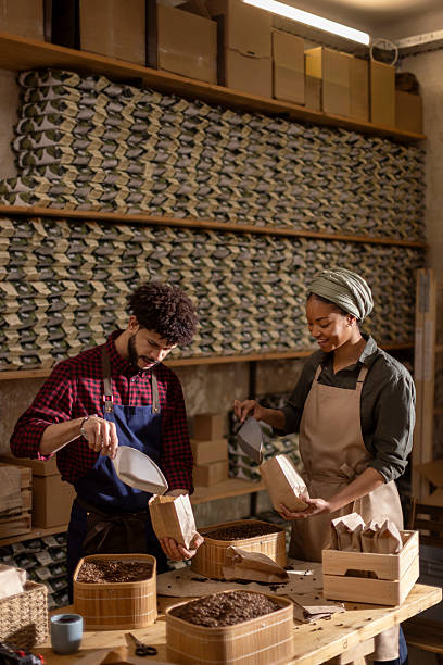 istock Two People Packaging Coffee Beans in a Rustic Warehouse Studio with Measuring Scoops and Paper Bags 2242459554