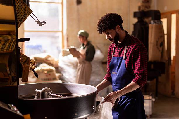 istock Focused Chef In Blue Apron Working With Large Pot In Industrial Kitchen During Coffee Preparation 2242459892