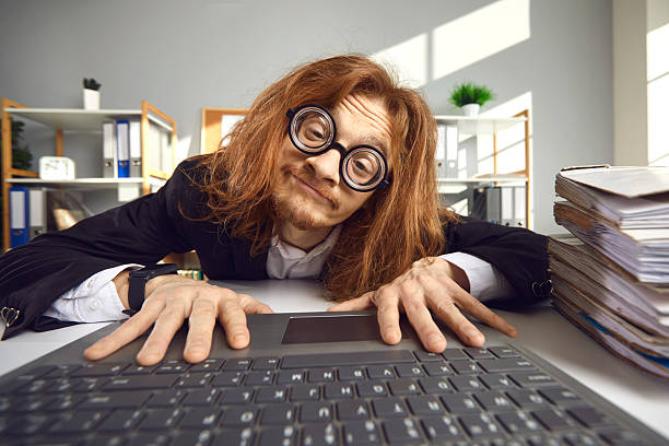 istock Funny nerd in glasses using laptop and searching for information on the Internet 2242459967