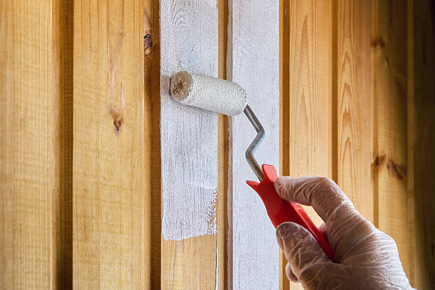 istock Painter applies paint with roller on wooden panels. 2242462996