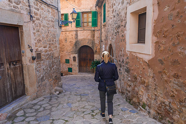 istock Woman walking through cobblestone alley in Valldemossa Spain 2242463077
