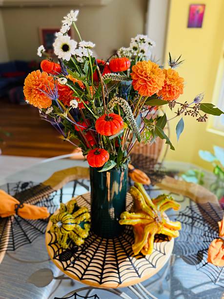 Beautiful bouquet of autumn flowers in pumpkin on bench outdoors. Beautiful floral decor for thanksgiving and halloween. Fall decor.