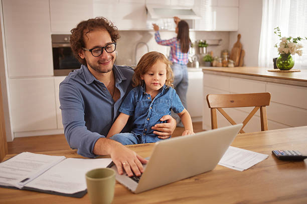 istock Father working from home with child on lap 2242466501