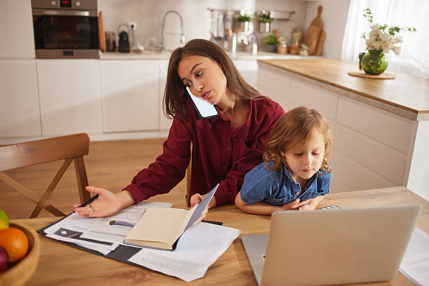 istock Working mom busy with paperwork and child at home 2242466599