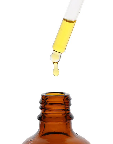 istock Dripping tincture from pipette into bottle isolated on white 2242466754