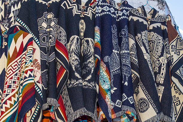 Traditional Andean ponchos in a variety of colors are displayed for sale at the weekly Plaza de los Ponchos market in Otavalo, Ecuador