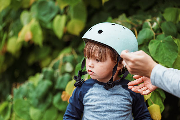 istock Little boy receiving help with bike helmet 2242468700