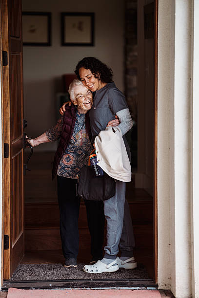 Elderly woman greeting home health nurse at front door