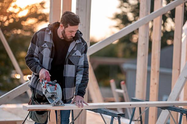 istock Carpenter Using Circular Saw to Cut Wood on Framing for New Home Construction at Sunset 2242470972
