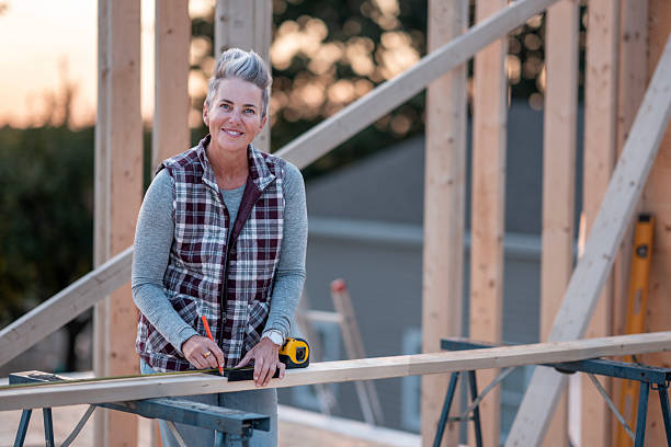 istock Older Woman Construction Worker Measures Wood On Site With Level And Pencil 2242470977