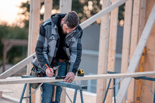 istock Caucasian Man Construction Worker Measures and Marks Wood Frame on Open House Construction Site 2242471029