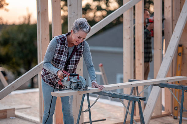 istock Older Woman Builder at Construction Site Cuts Wood With Circular Saw 2242471035