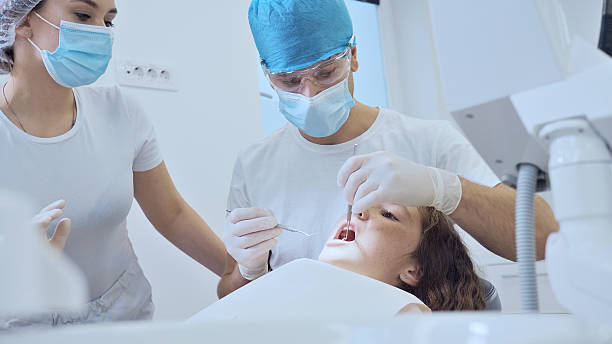 istock Dental Team Examining Young Patient in Modern Clinic 2242471056