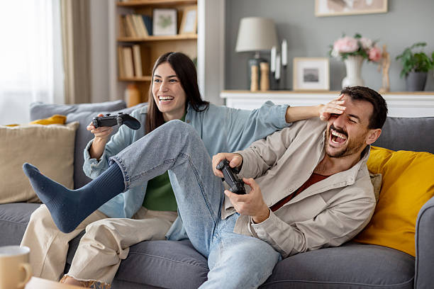 istock Excited Couple Enjoying Competitive Play on the Sofa 2242471762