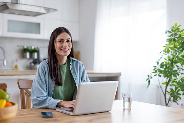 istock Smiling woman working on laptop in cozy home environment 2242471784